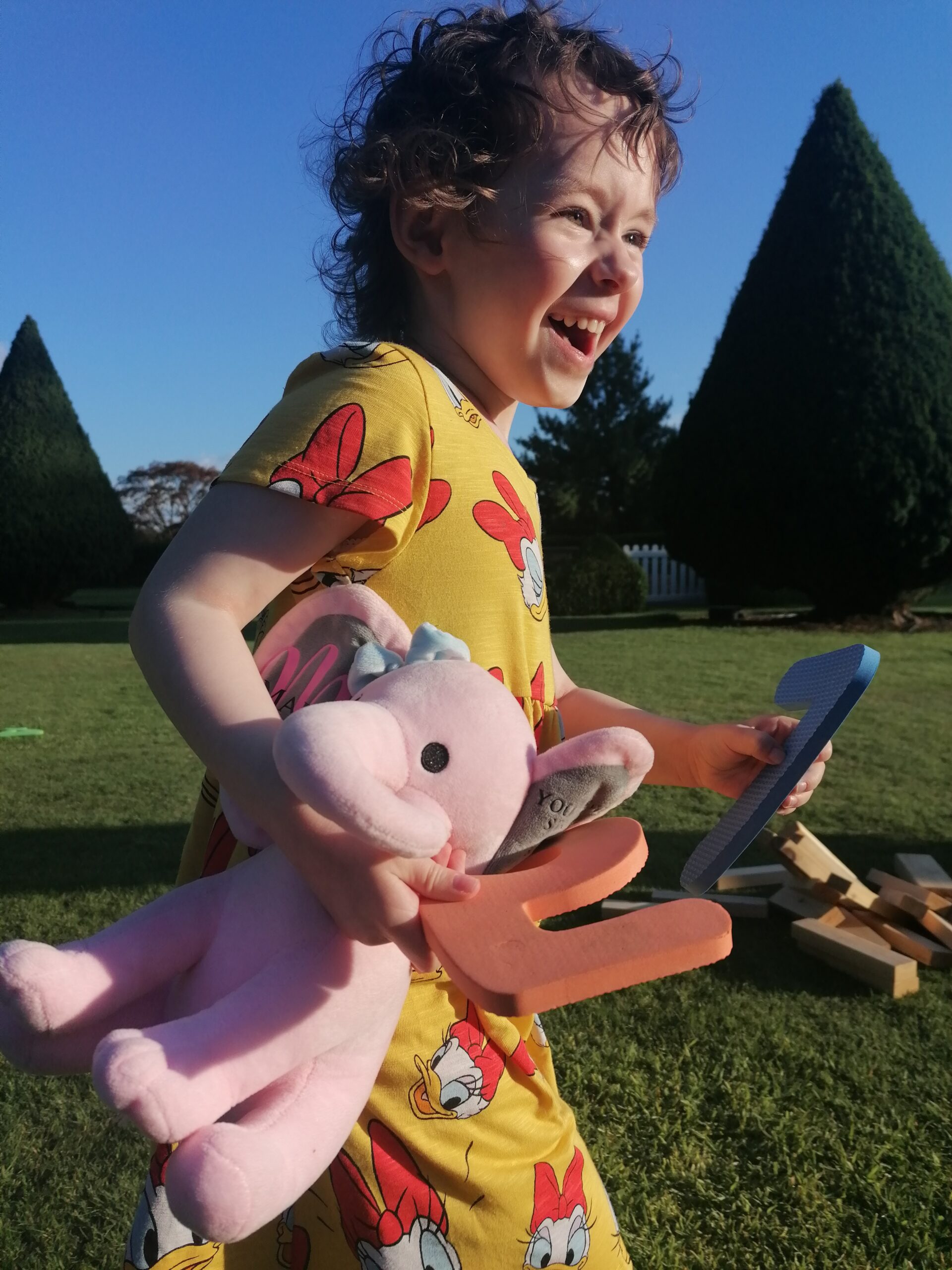 Photo of Marlie running with a teddy.