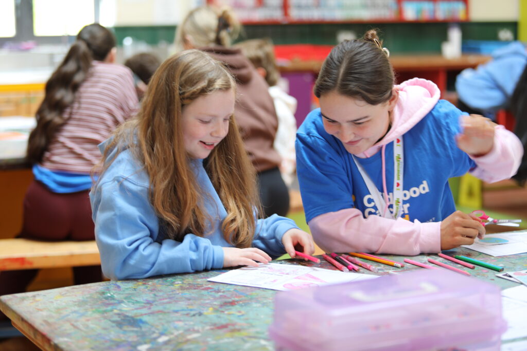A young girl is playing a game with a Childhood Cancer Ireland volunteer