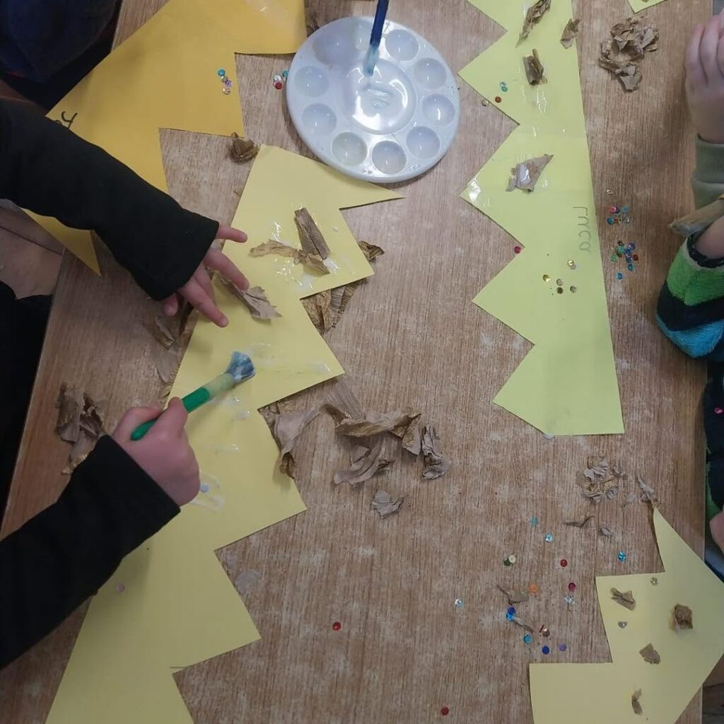 Small hands painting paper crowns