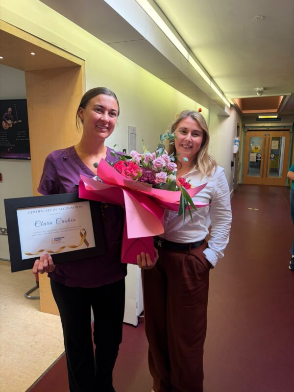 Photo of Laura Cullinan presenting a bouquet of flowers to Clara Cushen.